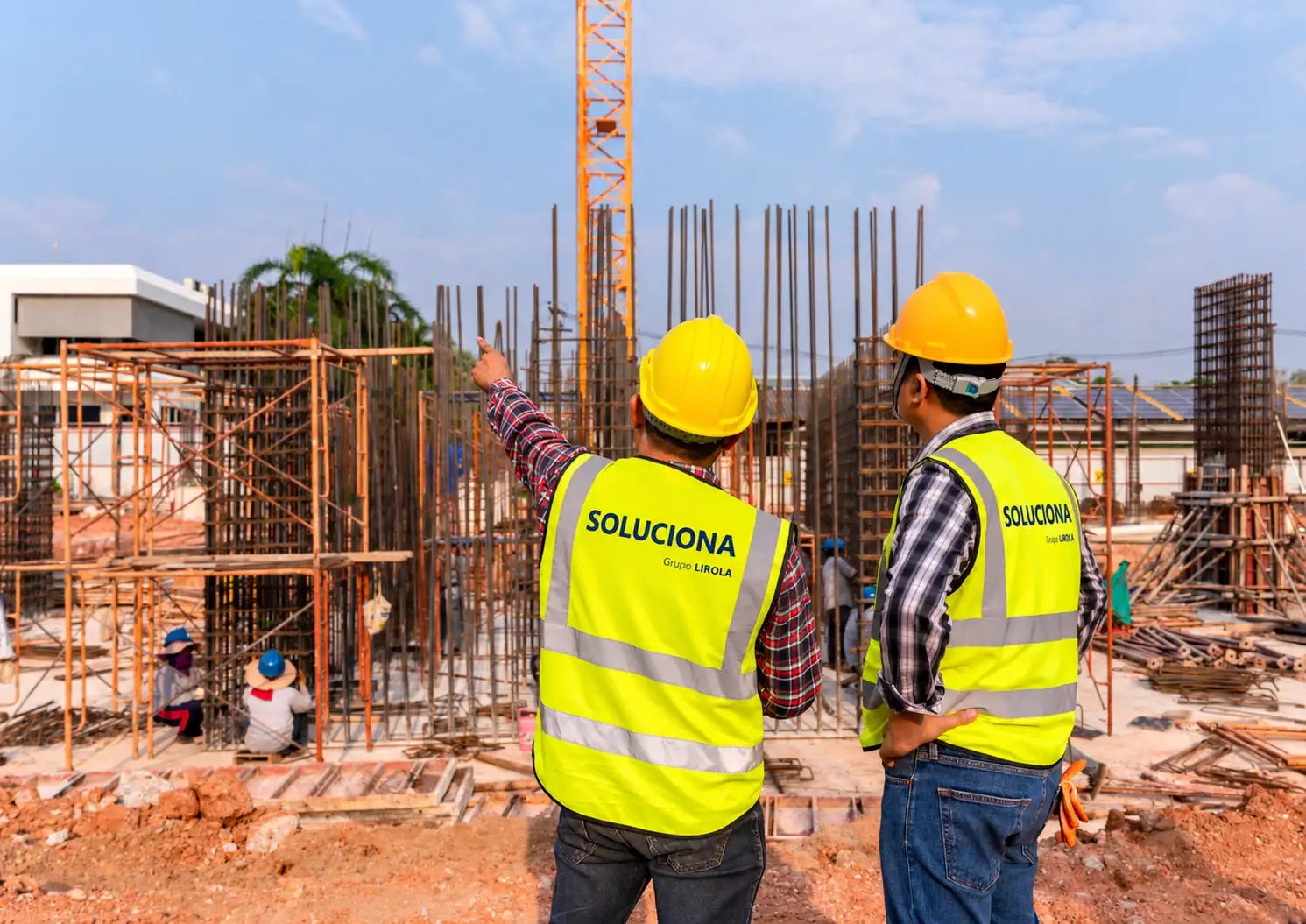 Dos técnicos de Soluciona con chaleco de la empresa supervisando una obra